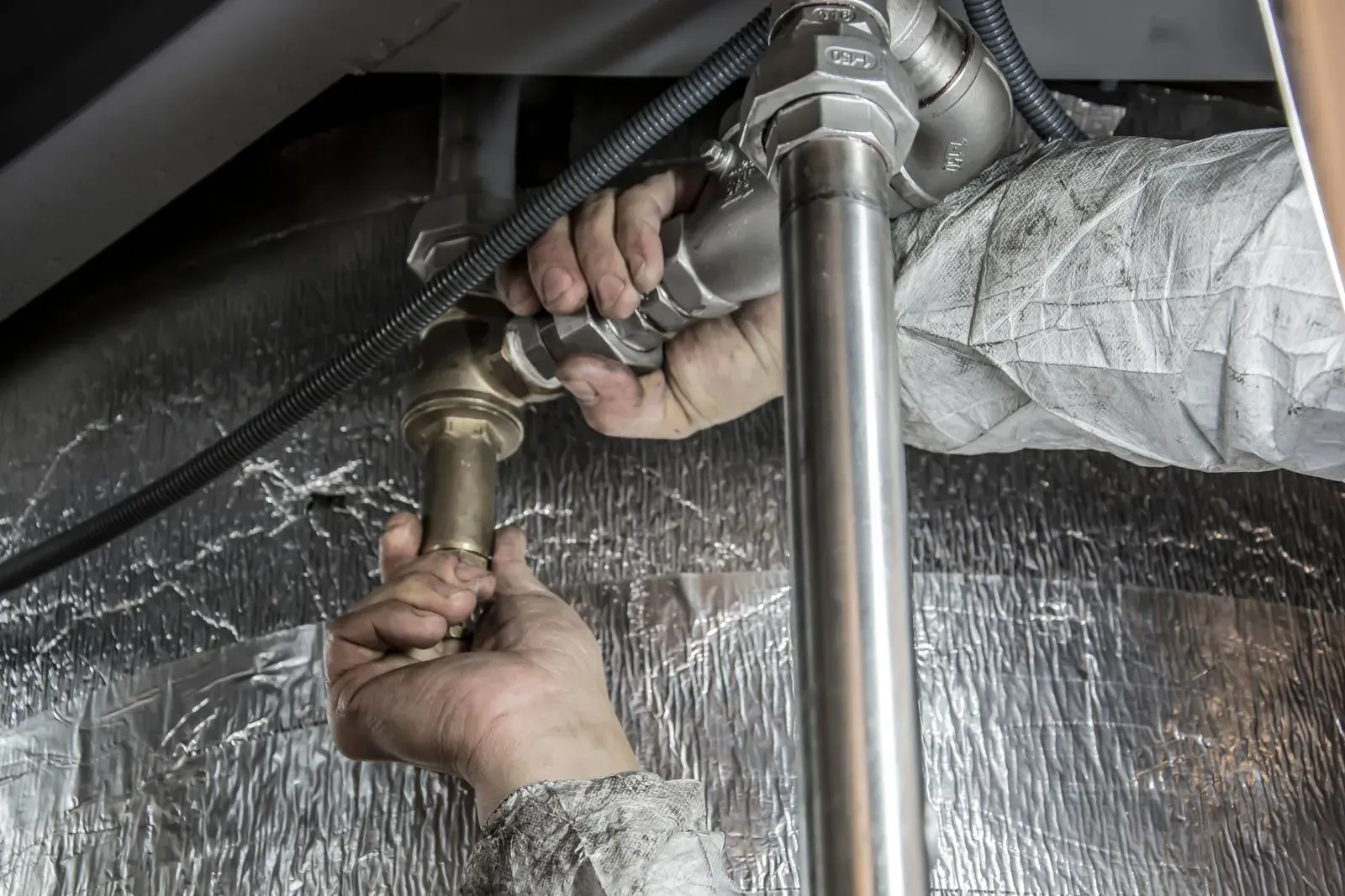 Plumber fitting a water pipe