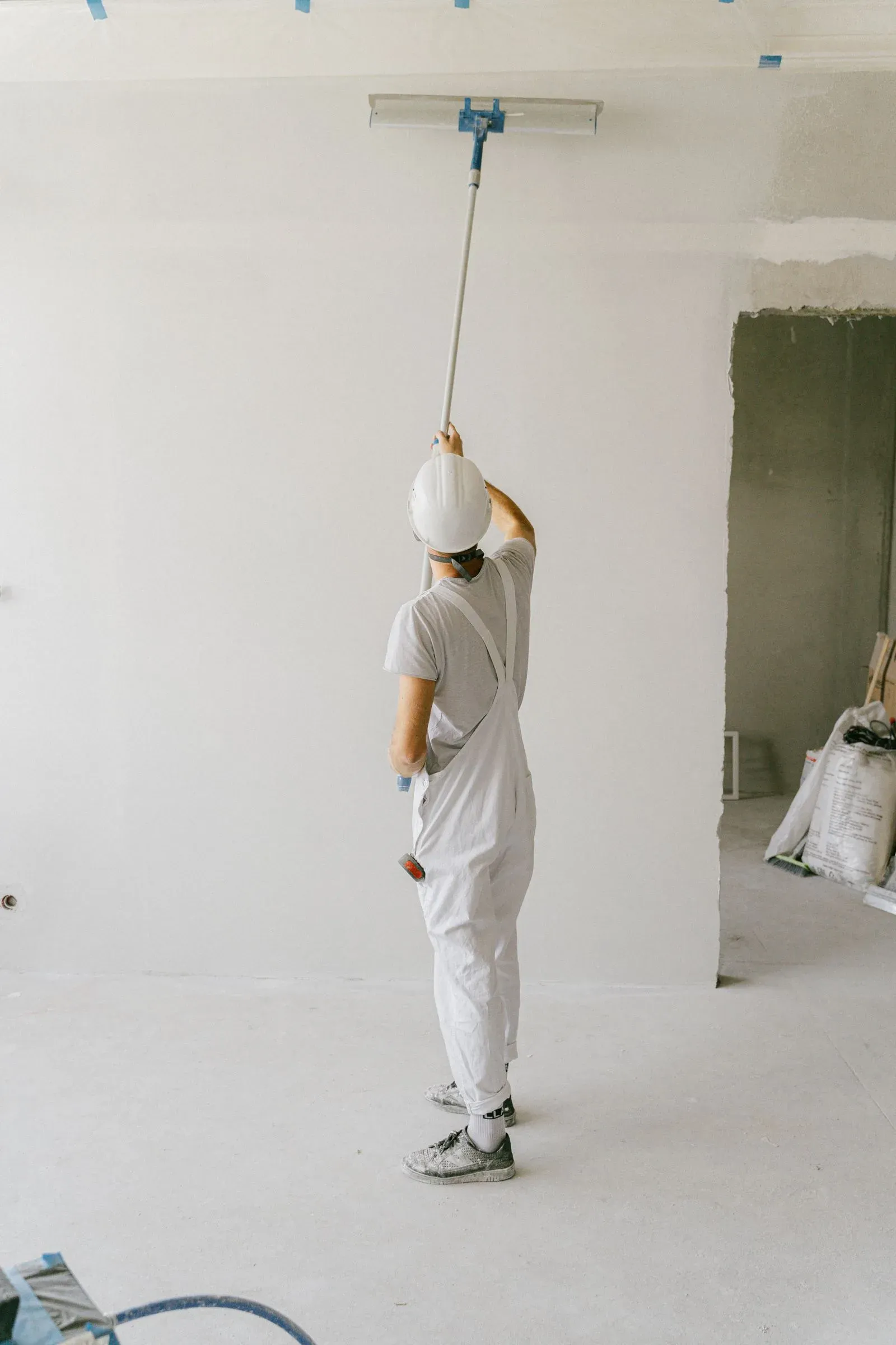 Painter rolling paint on a wall