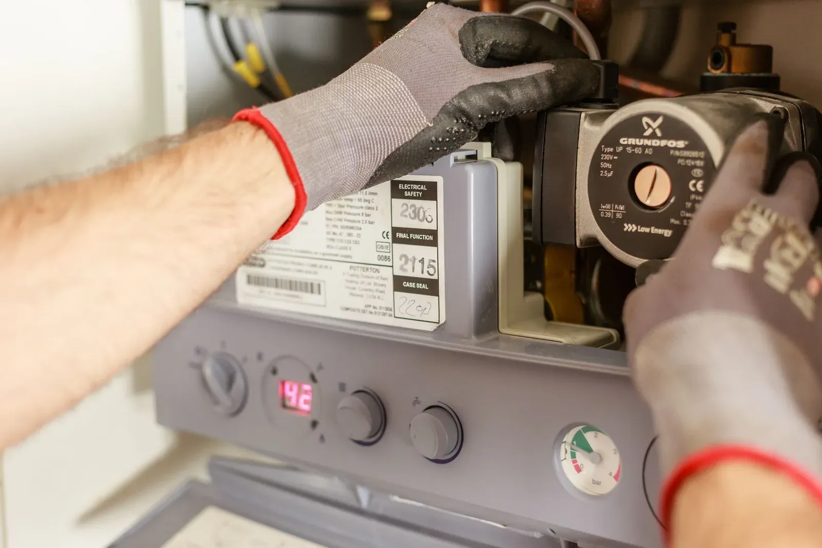 Technician in gloves repairing a gas water heater