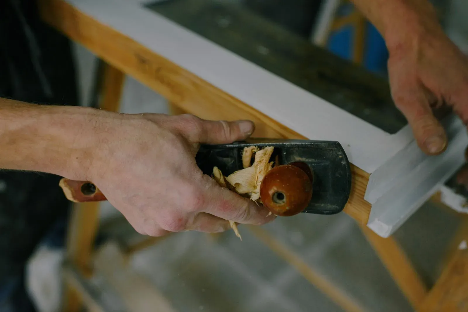 Carpenter planing a wooden window frame